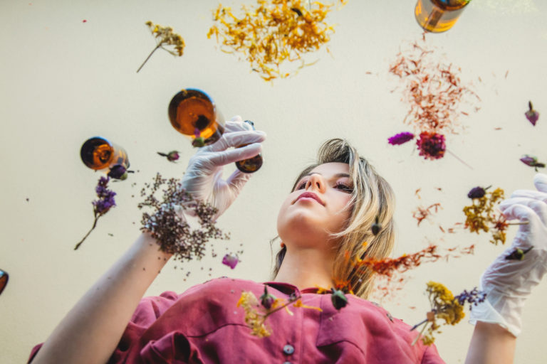 woman perfumer preparing herbs and flowers for make a perfume